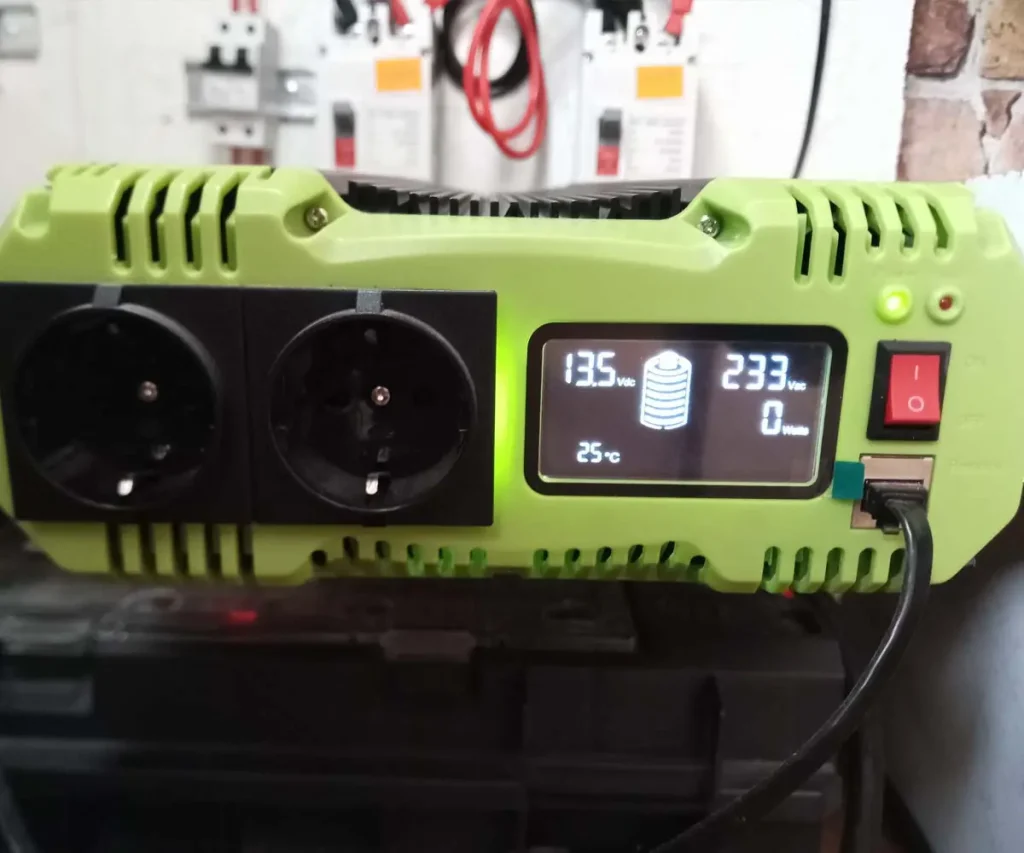 DIY 12V DC to 230V AC pure sine wave inverter front panel showing LCD display with battery voltage, AC output voltage, power consumption, and dual AC outlets.