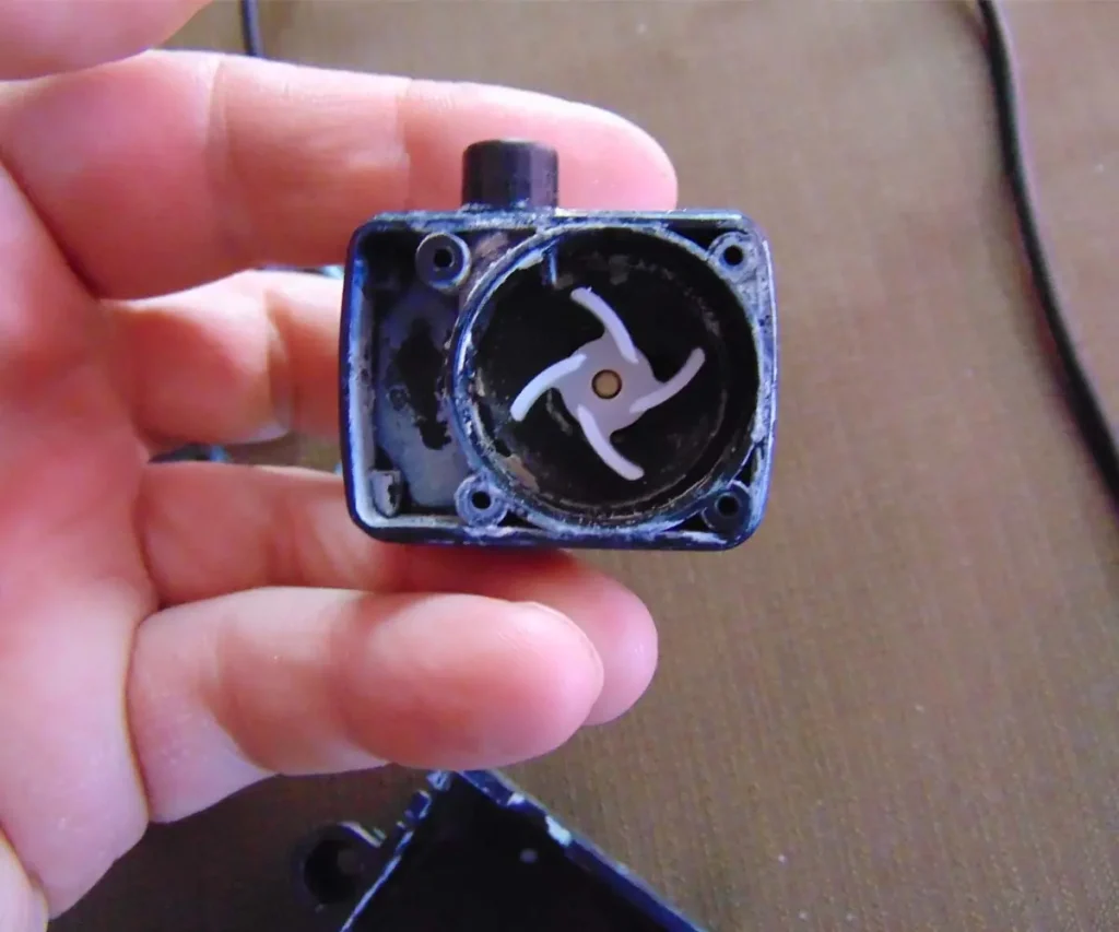 White mineral deposits and salt buildup inside a disassembled iDOO 12 hydroponic water pump impeller chamber