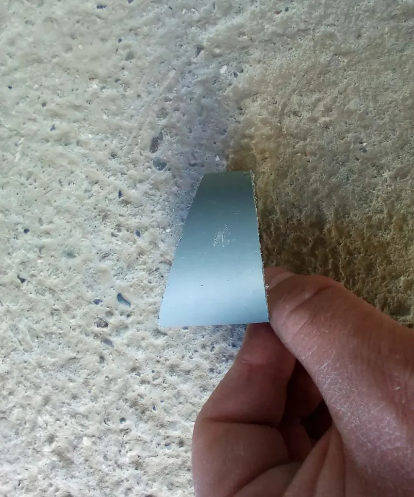 Close-up of a curved PVC sleeve cut from a pipe, used to reinforce planting holes in a DIY hydroponic tower.